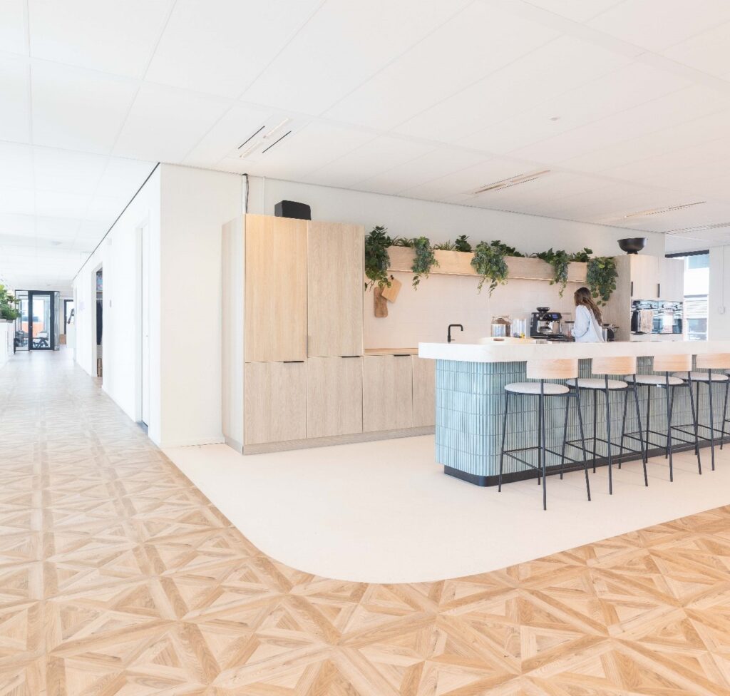 Moderne kantoorkeuken aan de Mt. Lincolnweg met licht interieur, een bar met krukken en groene planten als decoratie.